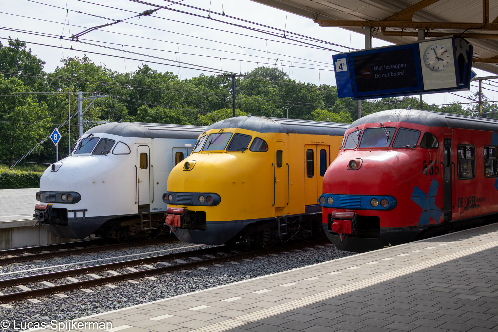 Mat '64 'De Karel' op het perron, naast een witte en een geel-NS uitvoering.
